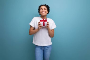 Beyaz tişörtlü genç İspanyol kadın bir doğum günü hediyesi aldı. tatil kavramı.