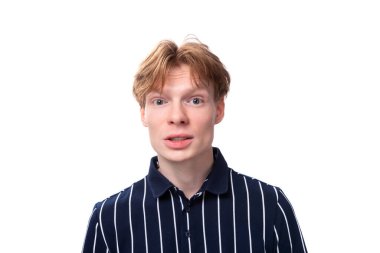 Beyaz arka planda bir sır saklayan şık, yakışıklı genç bir sarışının yakın plan portresi..