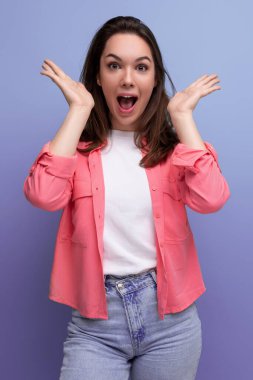 Gülümseyen esmer kadın, omuzlarının altında saçı olan, tişörtlü bir kadın şaşırma beklentisiyle gözlerini açtı..