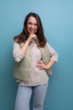 Gömlek ve yelek giymiş, gülümseyen esmer bir kadının portresi..