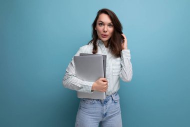 Avrupalı ince, 25 yaşında, kahverengi saçlı, dizüstü bilgisayarını tasarım için tutan genç bir iş kadını..