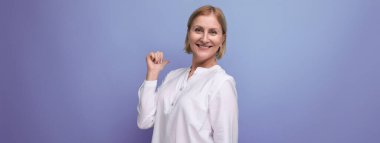 Beyaz bluzlu, esnek tenli, sarışın, 50 'li yaşlarda bir kadın..