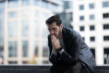 Stresli orta yaşlı bir adam sokakta otururken işten çıkarılıyor..