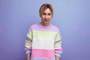 Hoş, gülümseyen sarışın genç bir kadının portresi. Mor bir arka planda, fotokopi alanı olan sıradan bir kadın..