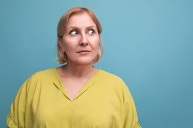 Şaşırmış orta yaşlı, kısa saçlı sarışın kadının portresi..