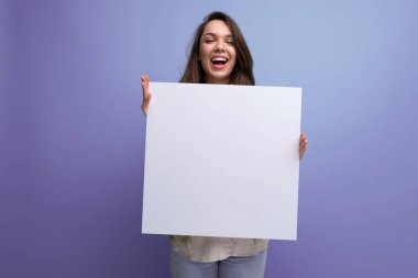 Pozitif genç esmer kadın beyaz çarşaf üzerinde reklam gösteriyor..