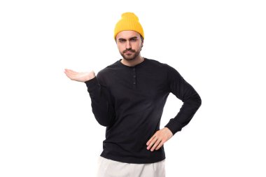 Gayri resmi olarak sakallı, bakımlı, beyaz, esmer bir adam ellerini yana doğru gösteriyor..