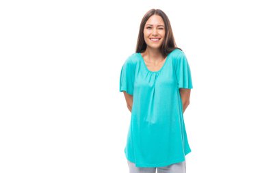 Siyah düz saçlı genç beyaz model stüdyo beyaz arka planda fotokopi alanı olan mavi bir tişört giyiyor..