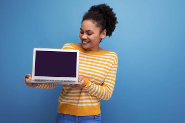 Güzel afro esmer Latin ofis kadını dizüstü bilgisayar tutuyor..