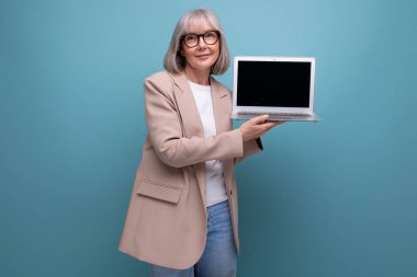 Kendine güvenen 60 'lı yaşlarda, ceketli, dizüstü bilgisayarlı ve fotokopi alanı olan orta yaşlı bir kadının yakın plan fotoğrafı..