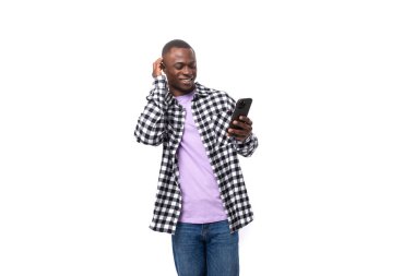 Ekose gömlekli yakışıklı Amerikalı genç adam akıllı telefonda sohbet ediyor..