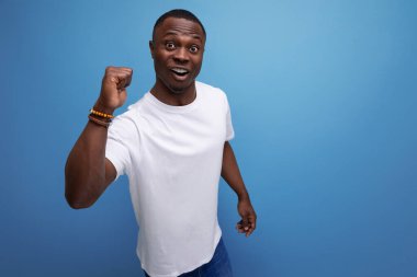 Başarılı, iyimser, beyaz tişörtlü Afrikalı genç adam..