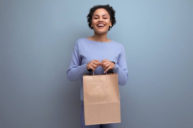 Mutlu esmer afro saçlı kadın geri dönüşümlü el sanatları paketinde teslimat aldı..