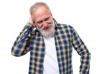 Bıyıklı ve sakallı olgun, gri saçlı emekli adam beyaz arka planda gülüyor..