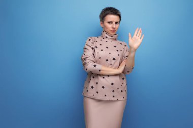 Kısa saçlı, etekli, bluzlu, esmer, ciddi bir beyaz kadın..