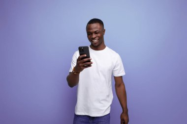 Beyaz tişörtlü pozitif Afrikalı adam internette sohbet ediyor..