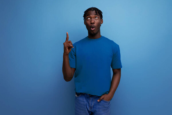 Ловкий вдохновленный американский молодой брюнетка мужчина в повседневной футболке с идеей.