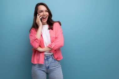 Neşeli esmer, gayri resmi görünüşlü bir kadın. Stüdyoda arkadaşıyla cep telefonuyla sohbet ediyor..