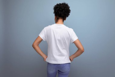 Genç İspanyol esmer kadın beyaz bir tişört giymişti ve arkası dönüktü..