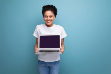 Beyaz tişörtlü, Latin kökenli genç, esmer bir bayan dizüstü bilgisayarla projesini sunmaya hazır..