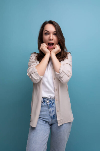surprised shocked young brunette female adult in casual shirt.