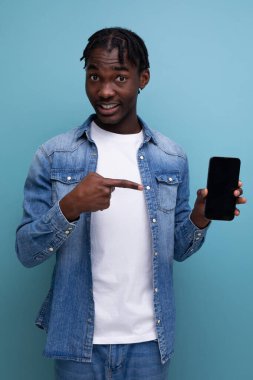 Gülümseyen siyah saçlı Afrikalı adam akıllı telefon kullanıyor..