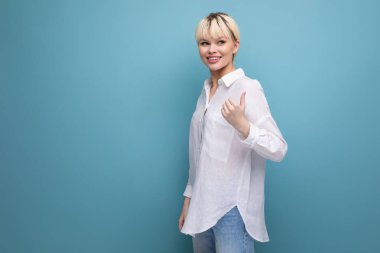 Kısa sarı saçlı beyaz bir ofis çalışanı beyaz bir bluz giyiyor ve arka planı mavi ve fotokopi alanı var. iş kavramı.