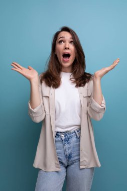 Şok olmuş Kafkas genç esmer kadın gömlekli ve kot pantolonlu ellerini havaya kaldırıyor..