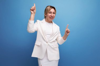 İyi giyimli, ince, sarışın, beyaz ceketli, etekli bir ofis kadını..