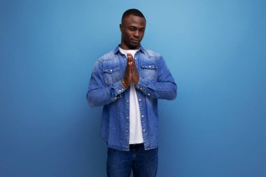 Çekingen, genç, utangaç, kentsel giyinmiş, arka planda kopya alanı olan Afrikalı bir adam..