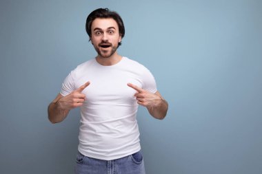 Kaslı, beyaz kolsuz tişörtlü, kendine güvenen esmer adam..