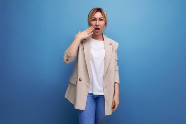 Stüdyonun arka planında, şaşırmış Avrupalı sarışın genç iş kadınının portresi.