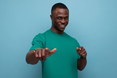 Tişört giymiş yakışıklı Afrikalı bir adam. Arka planda fotokopi alanı var..