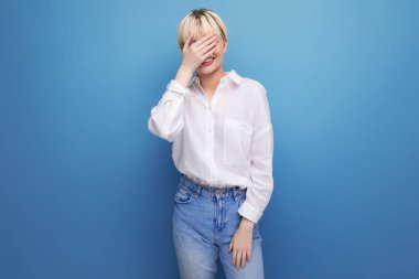 Beyaz bluz ve arka planda fotokopi alanı olan kot giyen kafası karışmış sarışın bir iş kadınının portresi. iş kavramı.