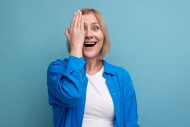 Mavi arkaplanda gülümseyen orta yaşlı kadın kopyalama alanı.