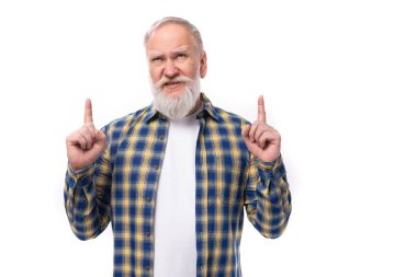 Olgun, gri saçlı, bıyıklı ve sakallı emekli adam beyaz arka planda bir stratejinin varlığını elleriyle gösteriyor..