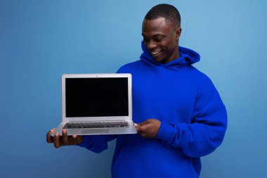 Yakışıklı Amerikalı genç danışman arka planda fotokopi alanı ile açık dizüstü bilgisayar gösteriyor.