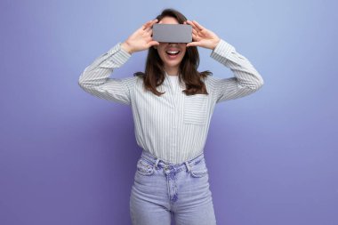 25 yaşında, bakımlı, kahverengi saçlı bir kadın telefonda reklamlar yapıyor..