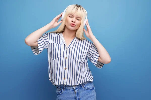 dancing cute blond 25 year old female person in a striped blouse with headphones.