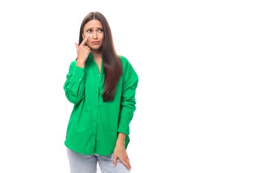 İyi giyimli, çekici, esmer, yeşil gömlekli, beyaz arka planda, fotokopi alanı olan bir kadın..