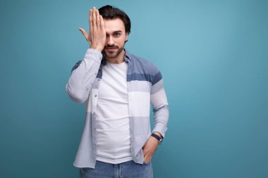 Manken görünümlü esmer adam elini stüdyonun arka planına koydu..