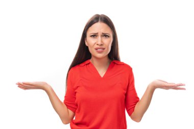 Kırmızı tişörtlü genç esmer kadın beyaz arka planda fotokopi çekilen kameraya şaşkınlıkla bakıyor..