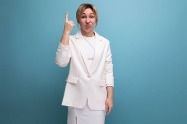 Beyaz, zarif ceketli ve etekli, ellerini havaya kaldırarak bağıran genç, duygusal sarışın işveren kadın..