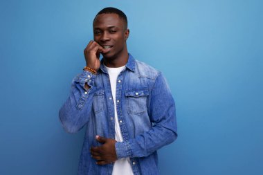 30 yaşında, kısa saçlı, kot ceketli ve beyaz tişörtlü yakışıklı bir Amerikalı adamın yakın plan portresi..