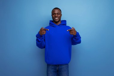 Pozitif, kısa saçlı, sıradan giyinmiş Afrikalı genç bir adam..