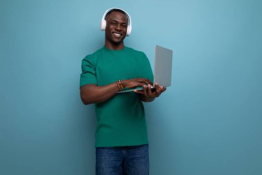 Basit bir tişört giymiş, bilgisayar alanında programcı olarak çalışan genç ve başarılı bir Amerikalı. Dizüstü bilgisayar tutan adam..