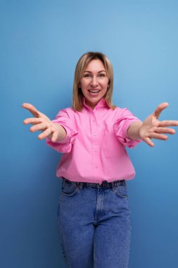 İlkbaharda sıradan giyinmiş, oldukça pozitif, sarışın Avrupalı bir kadın..