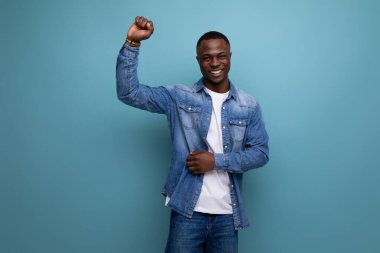 30 yaşında, gülen Amerikalı bir adamın portresi. Kısa saçlı, bahar kıyafetleri giymiş. Mavi arka planda, fotokopi alanı olan..