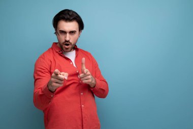 şık Avrupalı esmer 35 yaşında gömlekli bir adam kameraya elini gösteriyor..