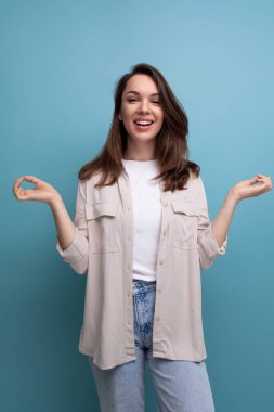 Güzel, siyah saçlı, bej gömlekli, zen pozlu, çekici 30 'lu yaşlarda bir kadın.